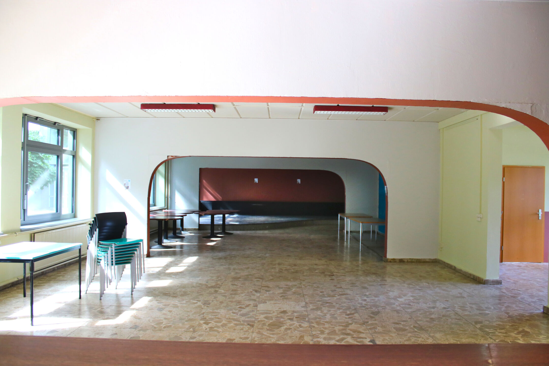 The large hall at the Club of Cultures, furnished with chairs, tables, and plenty of open space