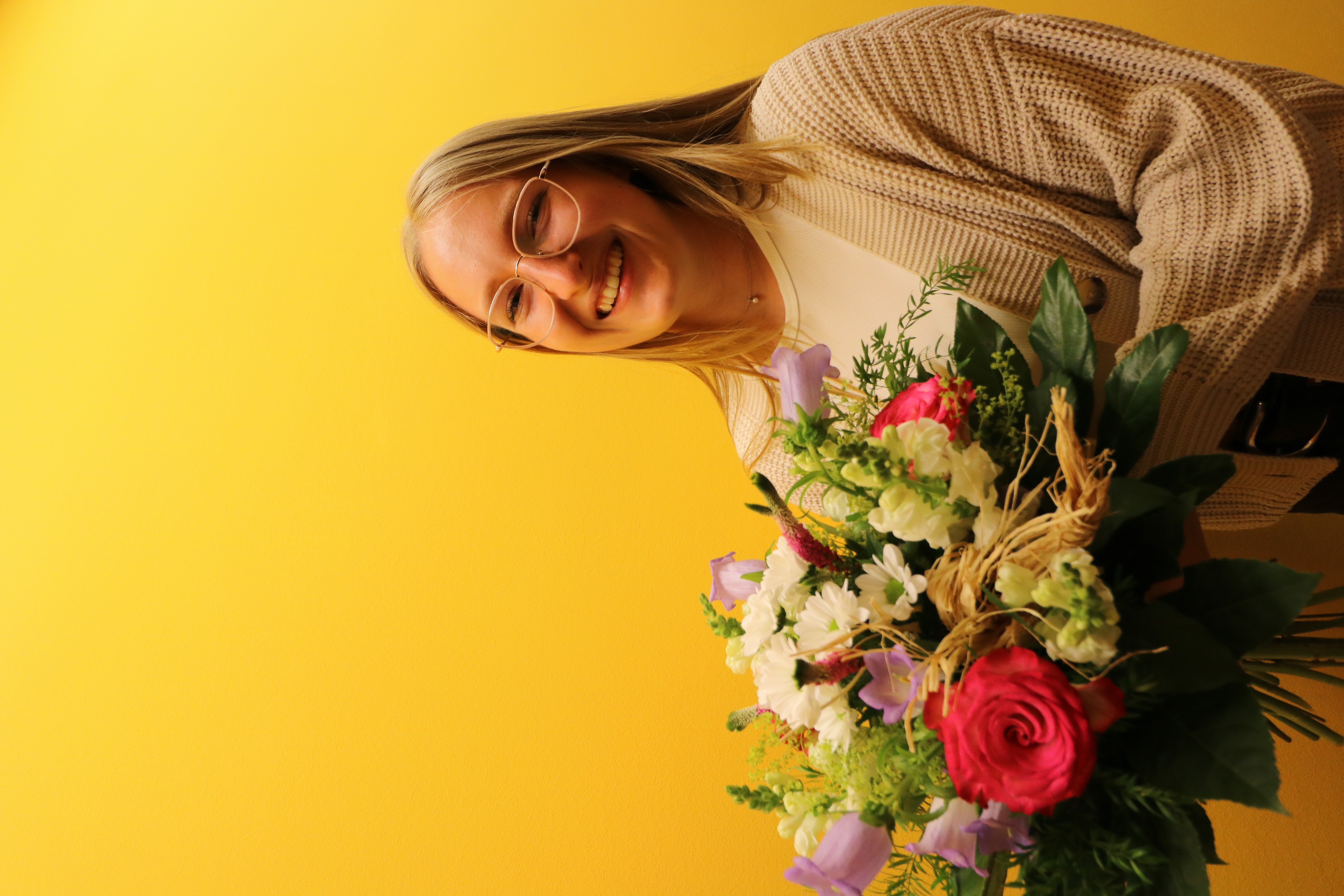 Chairperson of the Youth Advisory Council with a bouquet of flowers