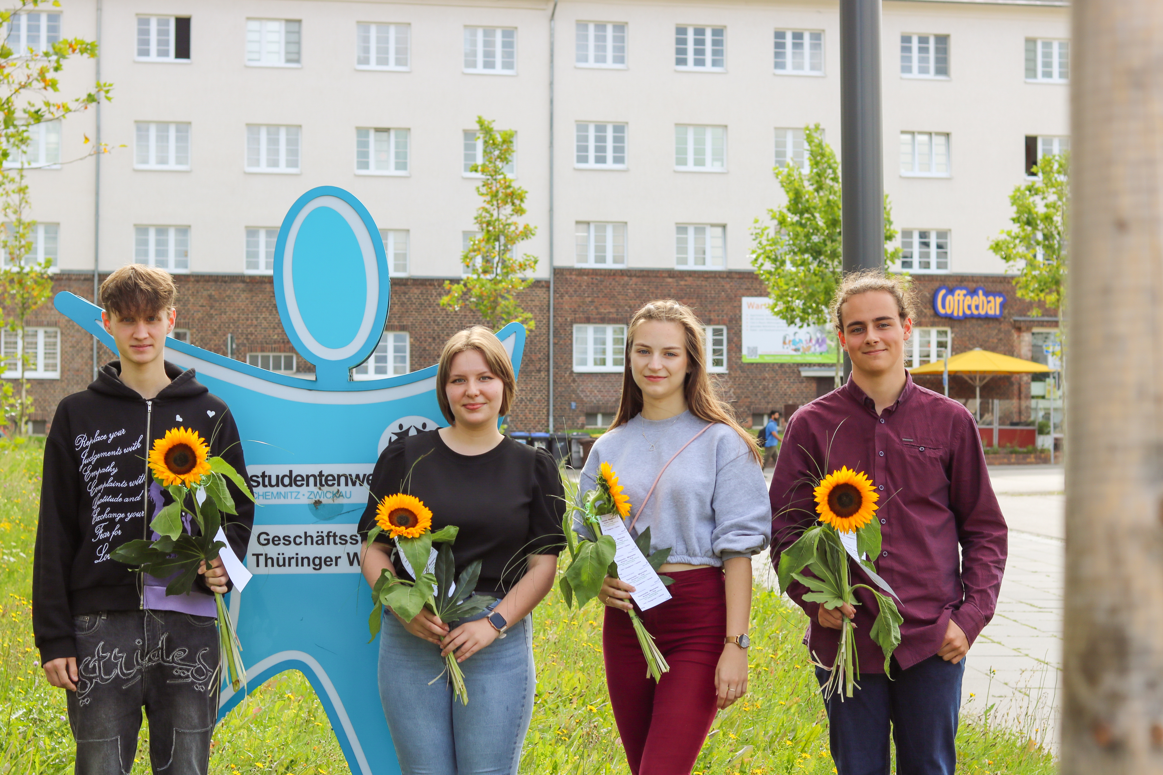 Four teenagers pose in front of the Chemnitz-Zwickau Student Services office as they begin their apprenticeships