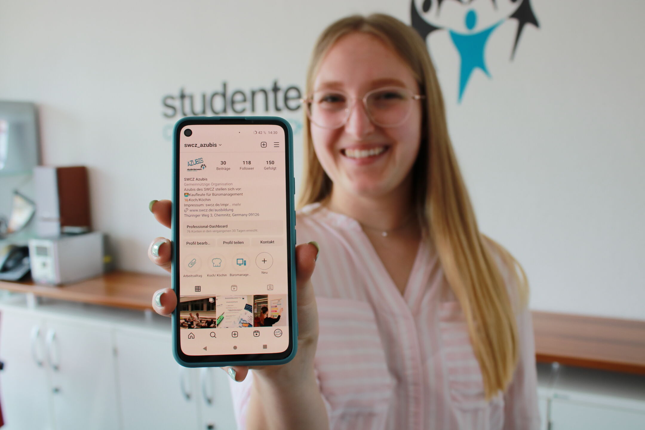 A teenager holds up a cell phone with an Instagram account visible on the screen