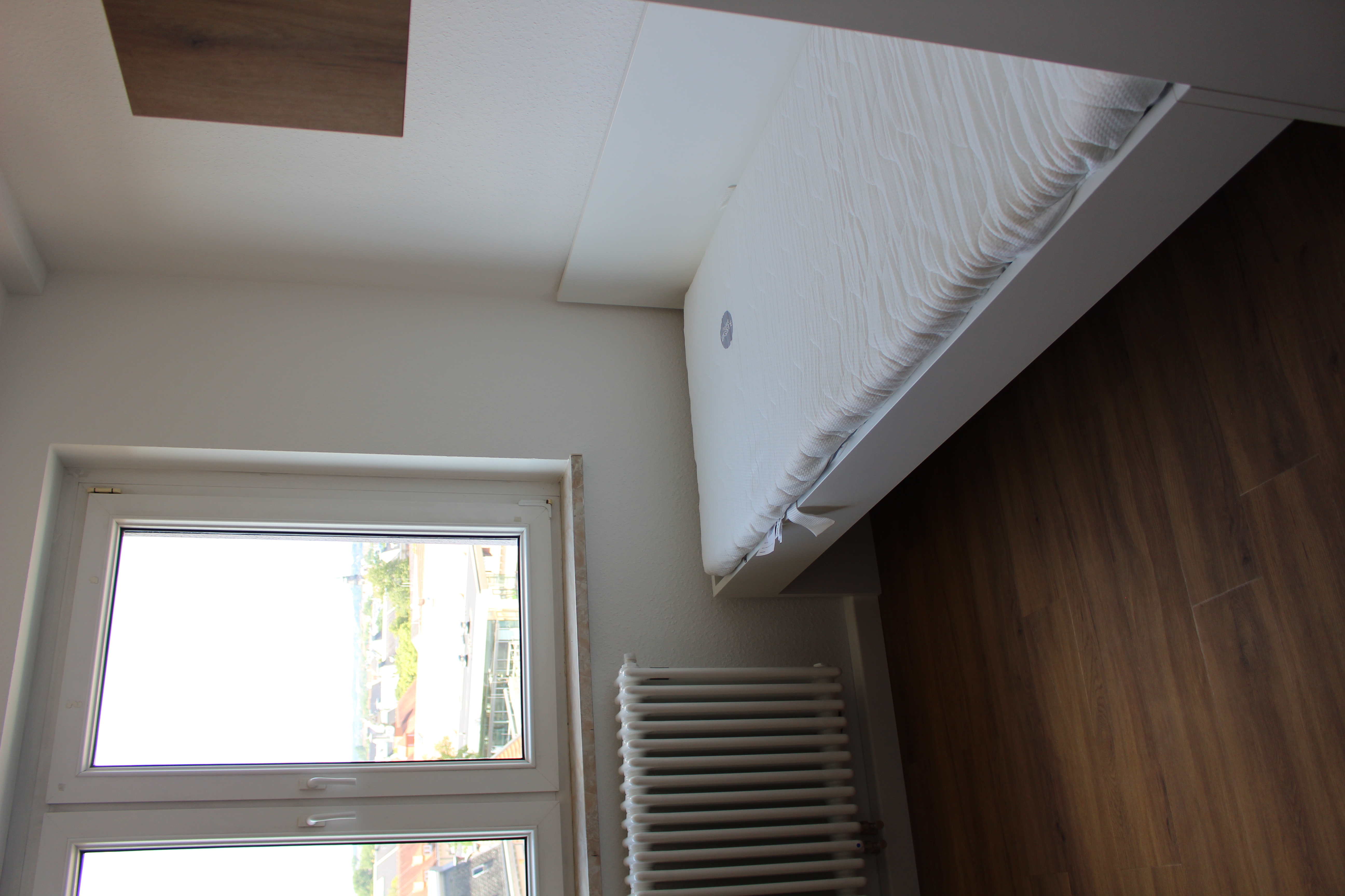 Bed with a window, view over the rooftops of Zwickau